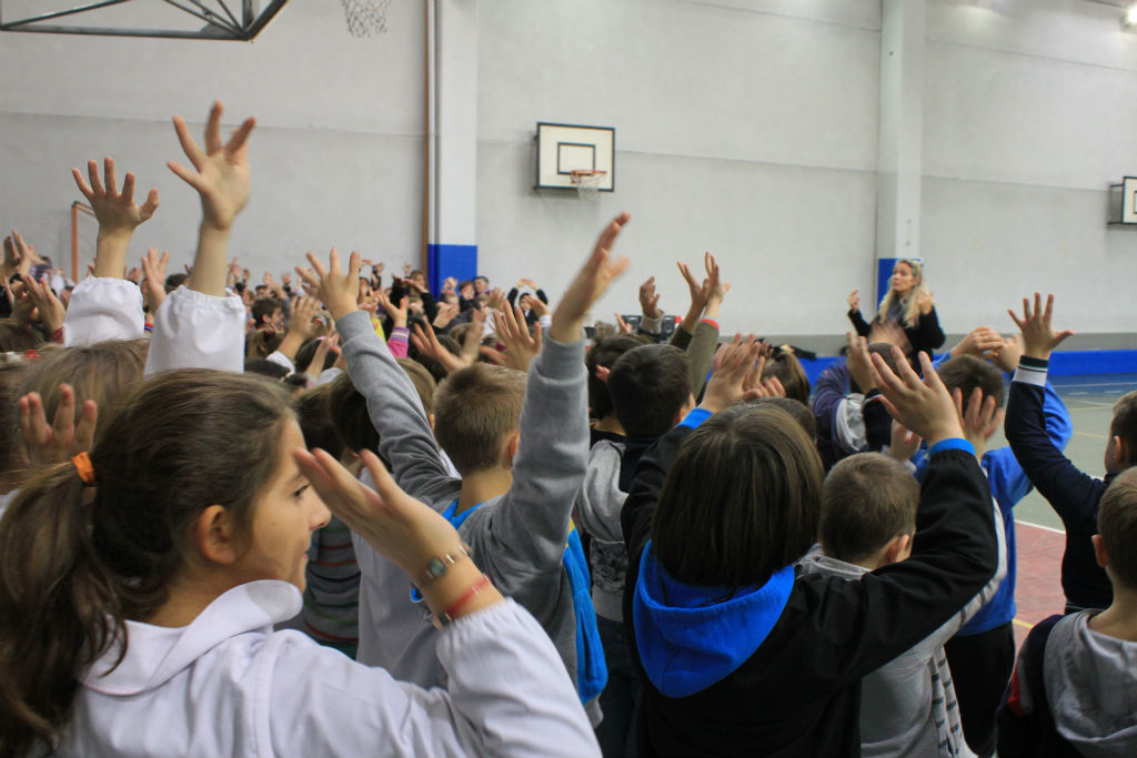 bambini che cantano e agitano le mani